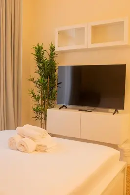 a bedroom with a tv and towels on a bed at Cosy Modern Studio Downtown Dubai in Dubai