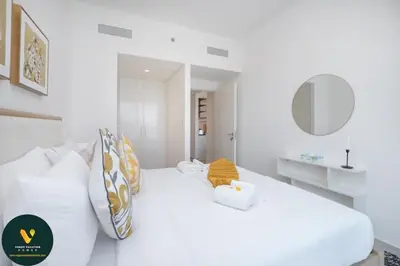 a white bedroom with two beds and a mirror at Vogue Downtown Views II with Direct Access to Dubai Mall Via a Climate Controlled Bridge, One Bedroom Apartment with Balcony and City View in Dubai