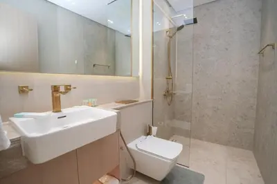 a bathroom with a sink and a toilet and a shower at Bright 1-Bed with Pool and Gym in Dubai