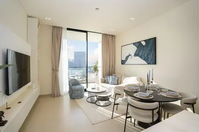 a living room with a table and chairs and a couch at Bright 1-Bed with Pool and Gym in Dubai