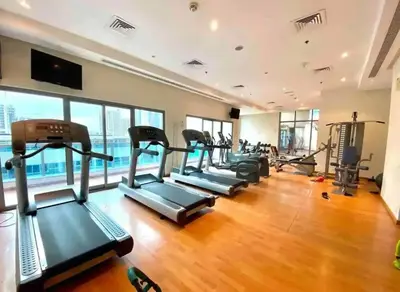 a gym with a row of treadmills and machines at Studio in Dubai Marina near by Beach & Metro Z1409 in Dubai