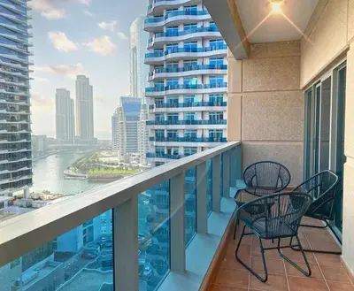 a balcony with two chairs and a view of a city at OneBedroom Apartment with Partial Sea view in Dubai Marina - Z1106 in Dubai