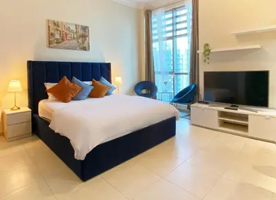 a bedroom with a large bed and a flat screen tv at Stylish Studio near the beach in Dubai Marina in Dubai