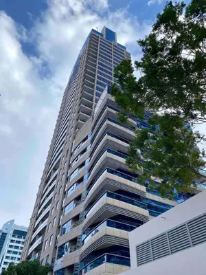 a tall building with a tree in front of it at Stylish Studio near the beach in Dubai Marina in Dubai
