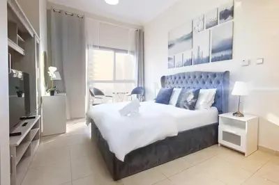 a bedroom with a large bed and a television at Enjoy Studio in Dubai Marina - Partial Marina View in Dubai