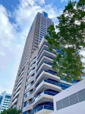 a tall building with a tree in front of it at Enjoy Studio in Dubai Marina - Partial Marina View in Dubai