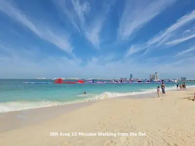 a group of people walking on a beach at Enjoy Studio in Dubai Marina - Partial Marina View in Dubai