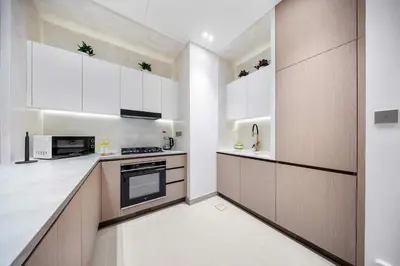 a kitchen with white cabinets and a stove at StayShort - Modern 1 Bedroom with Private Jacuzzi in JVC that Sleeps 2 in Dubai