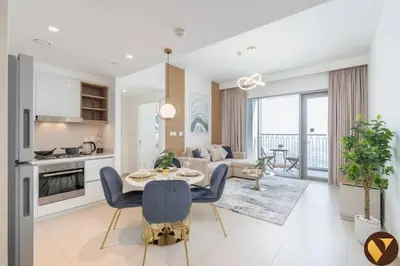 a kitchen and living room with a table and chairs at Vogue Downtown Views II with Direct Access to Dubai Mall Via a Climate Controlled Bridge, One Bedroom Apartment with Balcony and City View in Dubai