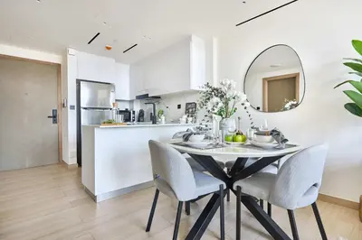 a kitchen and dining room with a table and chairs at Frank Porter - Binghatti Corner in Dubai