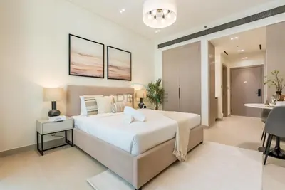 a bedroom with a large bed and a table at Prime Location, Walking Distance to Circle Mall, Minutes Drive from Dubai Marina and Palm Jumeirah - Binghatti Aurora, JVC by Deluxe Holiday Homes in Dubai
