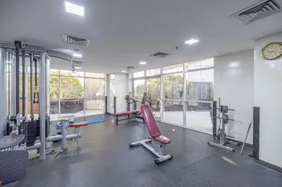 a gym with tread machines and a clock on the wall at Marina Escape Spacious Skyview 2BR in Dubai