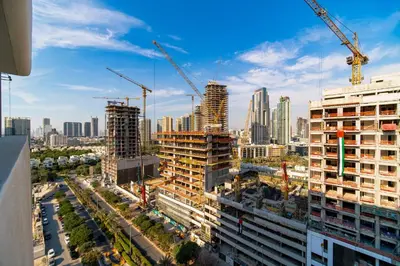 a view of a city under construction with cranes at SettlerHomes - Chic JVC Studio - Pool & Clubhouse in Dubai