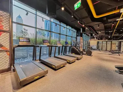 a gym with a row of treadmills and windows at Luxurious view of the Business Bay canal, 2 beds in Dubai