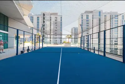 a tennis court in a building with tall buildings at Vogue JVC Binghatti Phantom near Circle Mall, One Bedroom Apartment with a Private Pool in Balcony and full Access to all Amenities in Dubai