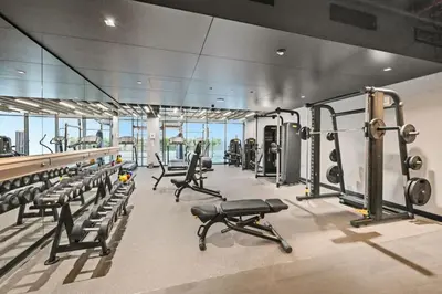 a gym with rows of treadmills and machines at Belgravia Heights 1 BHK in JVC in Dubai