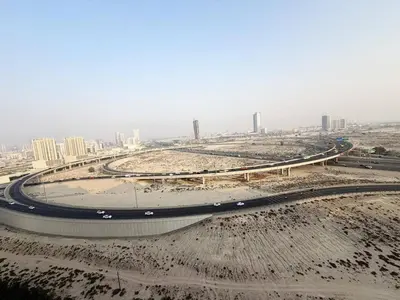 a curvy highway with a city in the background at Belgravia Heights II 1 BHK in JVC Luxury Living in Dubai