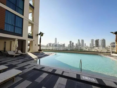 a swimming pool with a city skyline in the background at Belgravia Heights II 1 BHK in JVC Luxury Living in Dubai