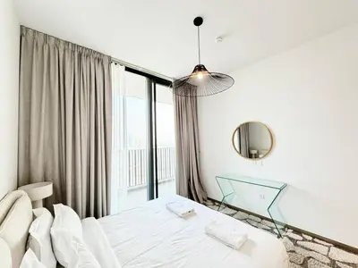 a bedroom with a bed and a large window at Belgravia Heights II 1 BHK in JVC Luxury Living in Dubai