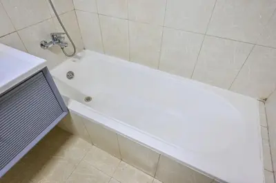 a white bath tub in a bathroom with a shower at Lake Point Tower 1 BHK by Petals Holiday Homes in Dubai