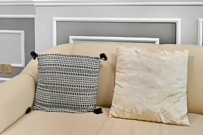 a couch with two pillows on top of it at Lake Point Tower 1 BHK by Petals Holiday Homes in Dubai