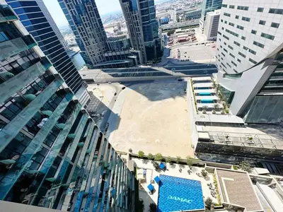 an aerial view of a pool in a city with tall buildings at Merano Tower 1BHK in Business Bay By Petals Holiday Homes in Dubai