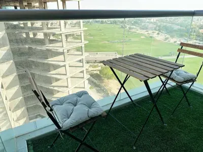 a balcony with a table and two chairs and a table at Comfortable Studio Retreat in Dubai Sports City in Dubai