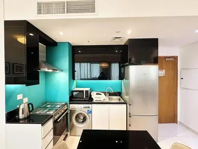 a kitchen with a refrigerator and a washing machine at Capital Bay Studio in Business Bay by Petals Holiday Homes in Dubai