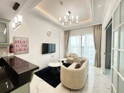 a living room with a couch and a tv at Vincitore Benessere 1BHK in Arjan by Petals Holiday Homes in Dubai