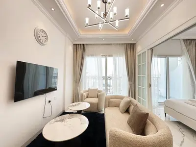 a living room with a couch and a tv at Vincitore Benessere 1BHK in Arjan by Petals Holiday Homes in Dubai
