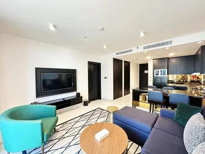 a living room with a couch and chairs and a tv at Elegant 1BR in Business Bay in Dubai