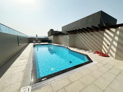 a swimming pool on the roof of a building at Profile Residency Studio near Dubai Stadium by Petals Holiday Homes in Dubai