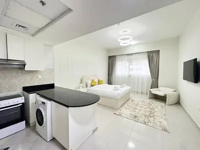 a kitchen and living room with a stove and a microwave at Profile Residency Studio near Dubai Stadium by Petals Holiday Homes in Dubai