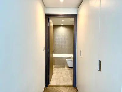 a bathroom with a toilet and a door to a tub at 1 Residence 1BHK near Metro by Petals Holiday Homes in Dubai