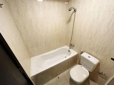 a bathroom with a toilet and a bath tub at Cordoba Palace Studio In Silicon Oasis by Petals Holiday Homes in Dubai