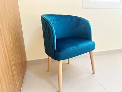 a blue chair sitting next to a wall at Cordoba Palace Studio In Silicon Oasis by Petals Holiday Homes in Dubai