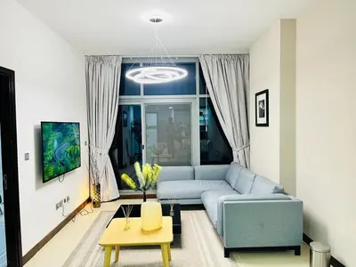 a living room with a blue couch in front of a window at Indigo Tower 1 BR in JLT by Petals Holiday Homes in Dubai