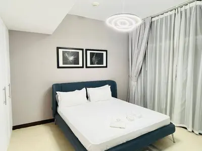 a bedroom with a bed with white sheets and a window at Indigo Tower 1 BR in JLT by Petals Holiday Homes in Dubai
