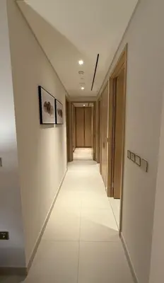 a hallway with white walls and a long white tile floor at Luxurious 2 Bedroom Apt in VDM Residences - Full Burj Khalifa View in Dubai