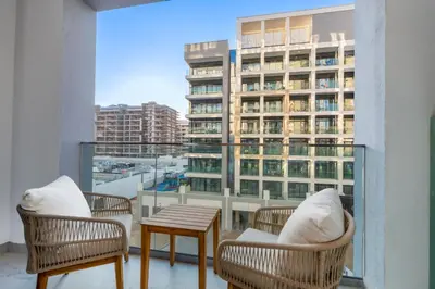 a balcony with chairs and a table and a building at Modern Std Near Burj Khalifa with Pool and City Views in Dubai