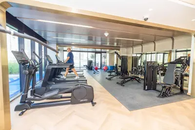 a man running on a treadmill in a gym at Modern Std Near Burj Khalifa with Pool and City Views in Dubai
