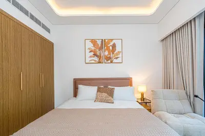 a bedroom with a bed and a chair at Modern Std Near Burj Khalifa with Pool and City Views in Dubai