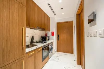 a kitchen with wooden cabinets and a dishwasher at Modern Std Near Burj Khalifa with Pool and City Views in Dubai