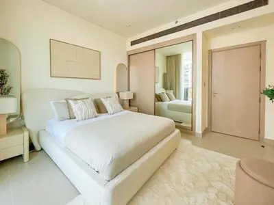 a white bedroom with a large bed and a mirror at Binghatti Aurora Soft-Luxe 1BR Abode w Gym & Pool in Dubai