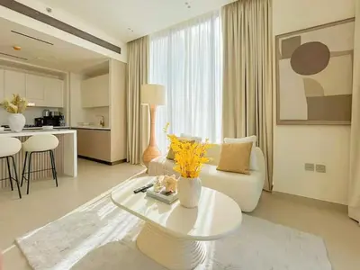 a living room with a white couch and a table at Binghatti Aurora Soft-Luxe 1BR Abode w Gym & Pool in Dubai