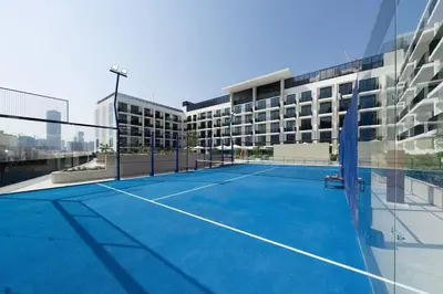 a tennis court in front of a building at Binghatti Aurora Soft-Luxe 1BR Abode w Gym & Pool in Dubai