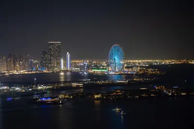 a large ferris wheel in a city at night at Luxury 1BR on Palm Jumeirah with Pool Access and Beach in Dubai