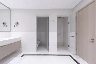 a white bathroom with a toilet and a sink at Luxury 1BR on Palm Jumeirah with Pool Access and Beach in Dubai