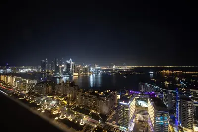 a view of a city at night with lights at Luxury 1BR on Palm Jumeirah with Pool Access and Beach in Dubai