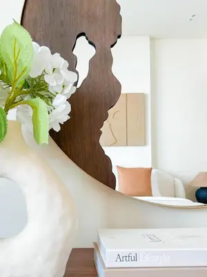 a vase with a flower in front of a mirror at Warm Modern 1BR Haven with Balcony & Free Parking in Dubai